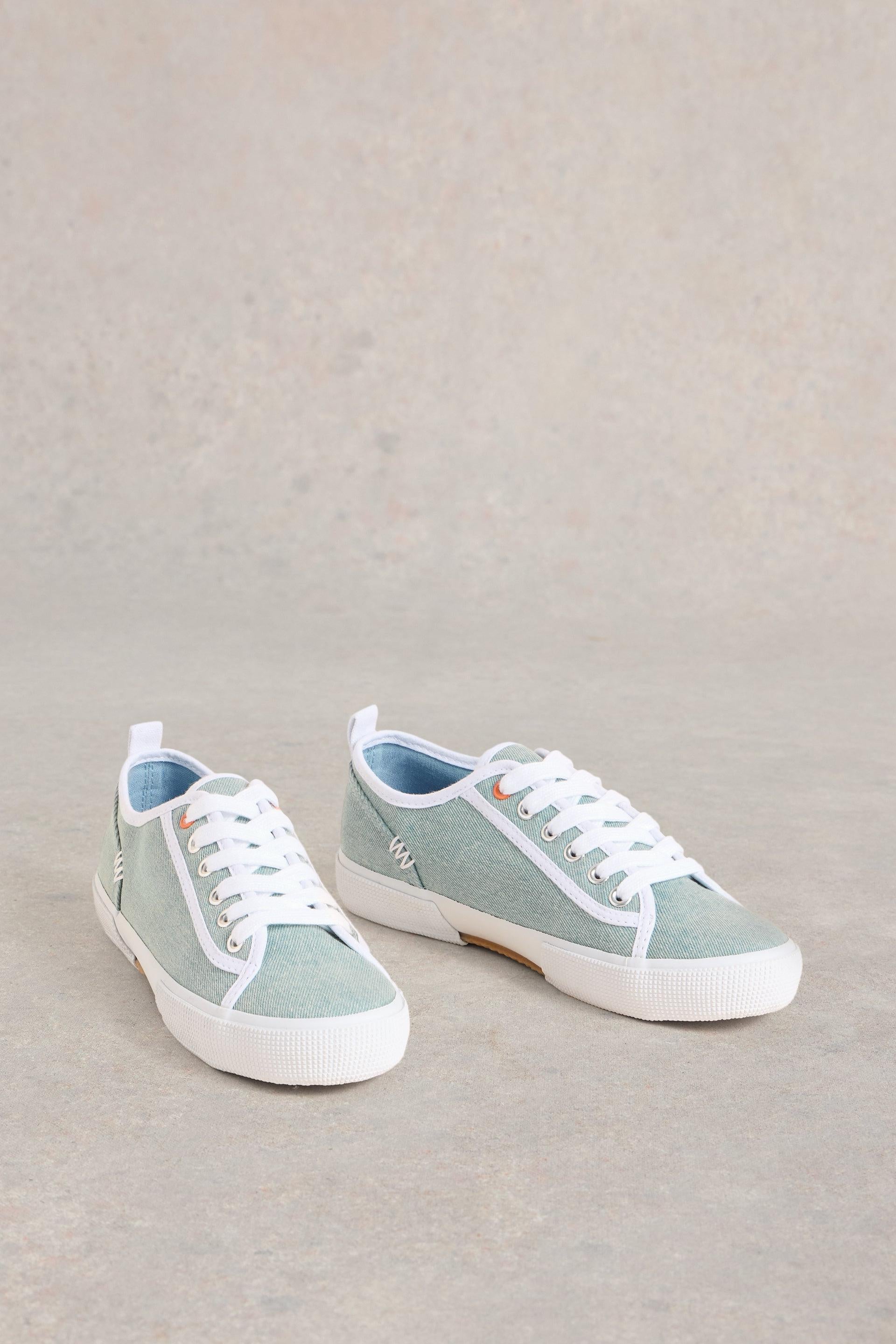 Side of canvas trainers with hand-stitched details.
