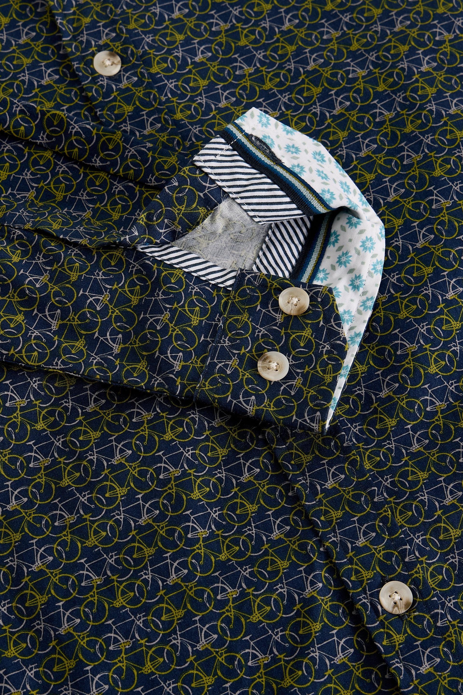 Close-up of a patterned shirt with a decorative bicycle design on a dark blue background.