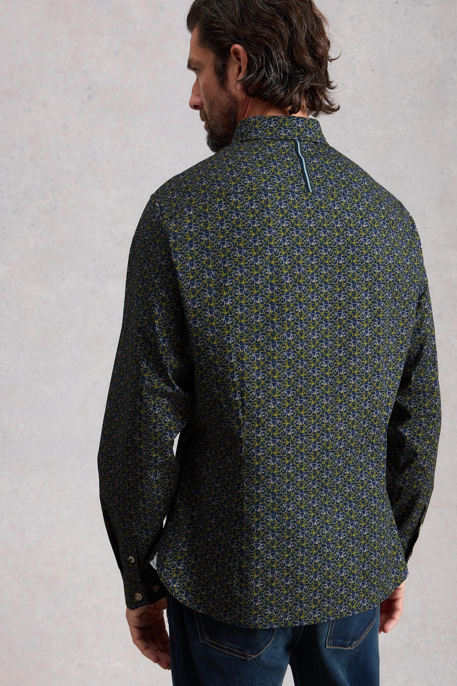 Man wearing a patterned shirt with a neutral background