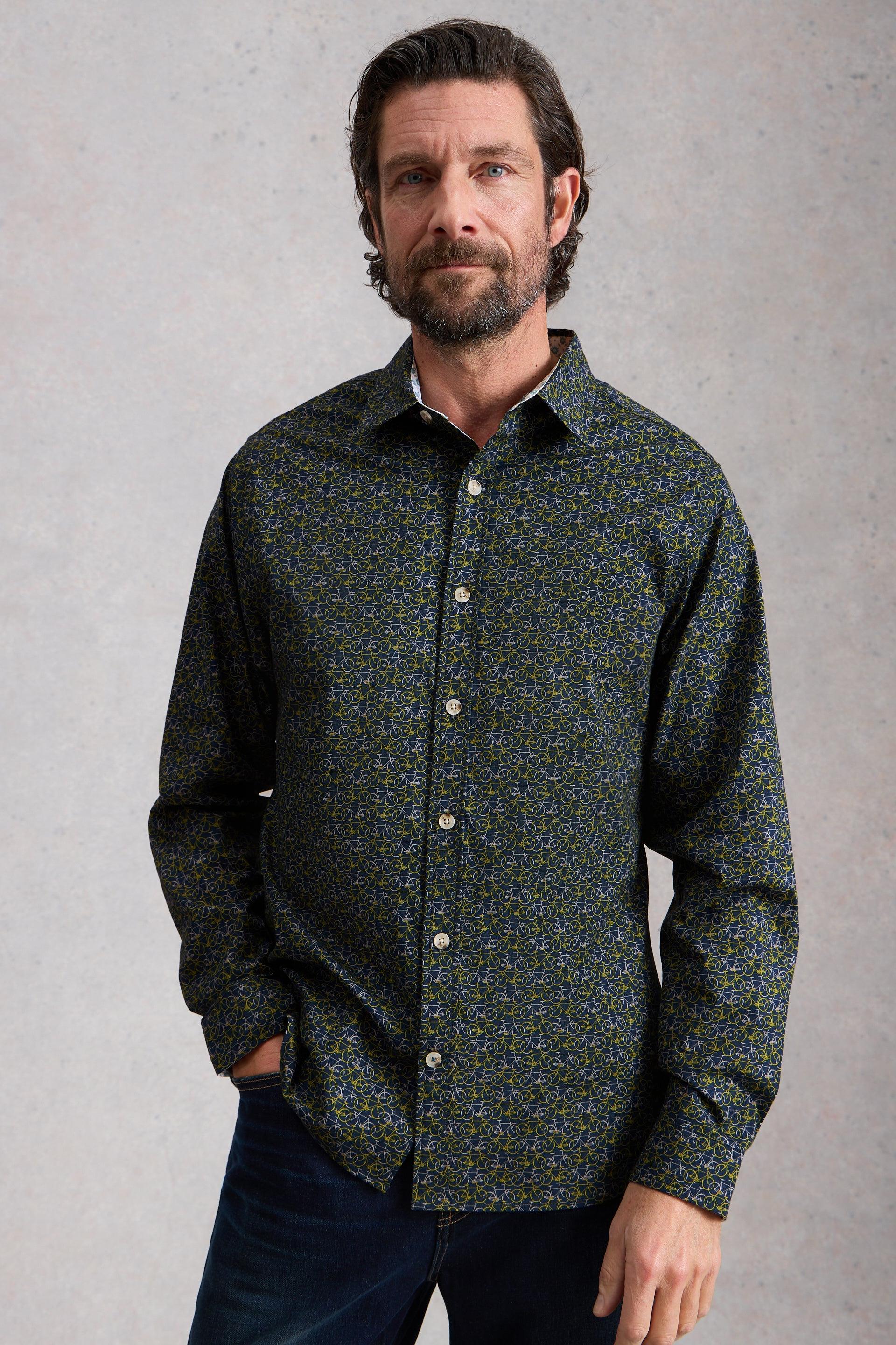 Man wearing a dark patterned organic cotton shirt against a gray background