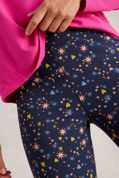 Navy organic cotton leggings with colourful star and heart pattern worn by a person in a pink top