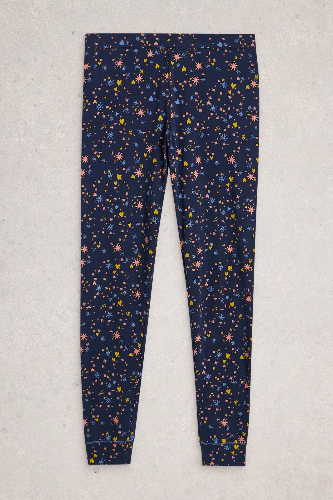 Navy pyjama leggings with colourful star pattern on a light gray background