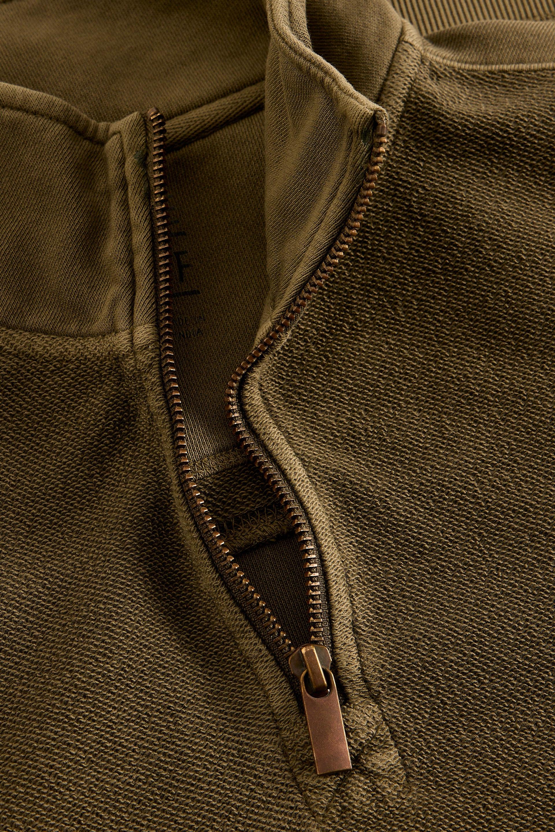 Close-up of a green organic cotton jumper with a zipper