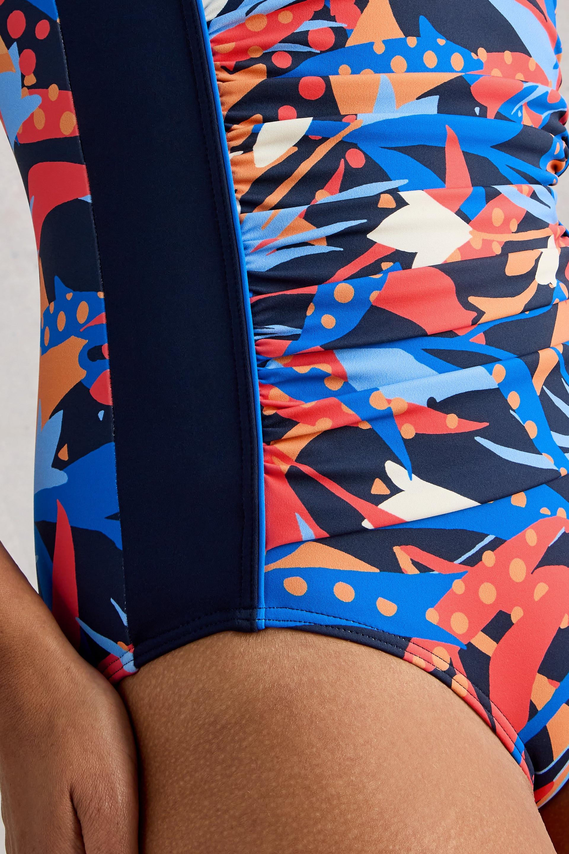 Colorful swimsuit with abstract pattern and elasticated waist on a person wearing it.