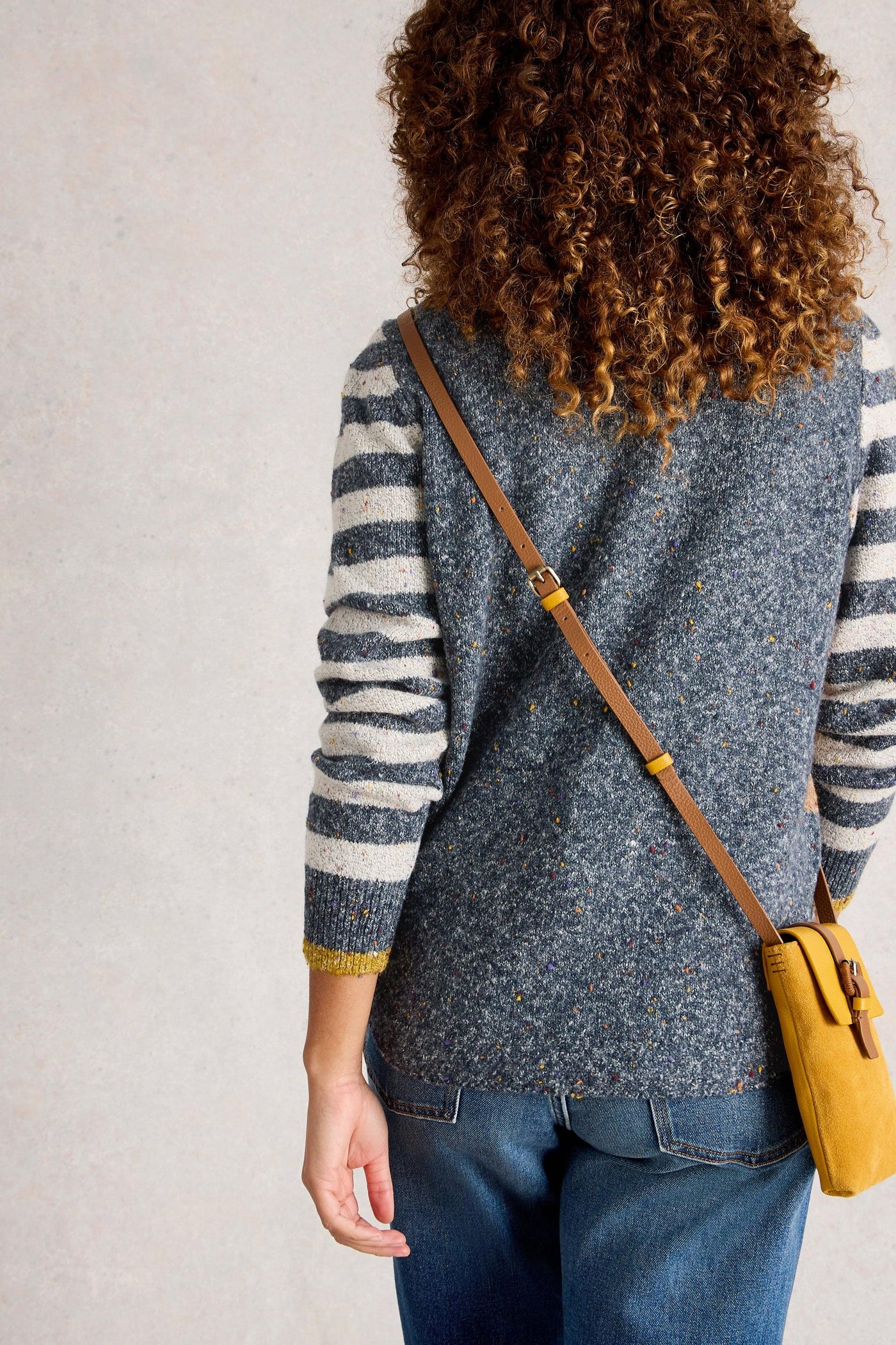 Back view of organic cotton knit jumper showing a blue back and white and blue striped sleeves