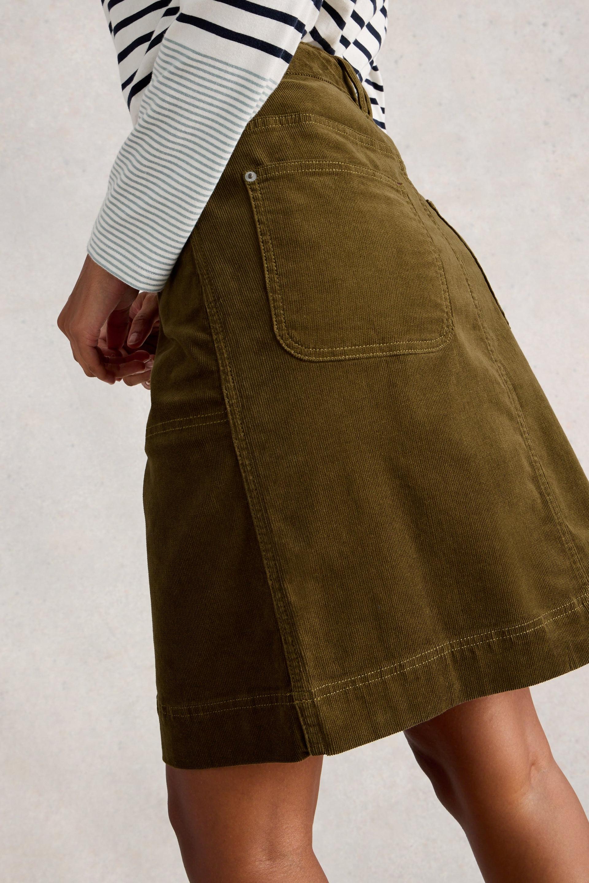 Person wearing a green organic cotton skirt with a white background
