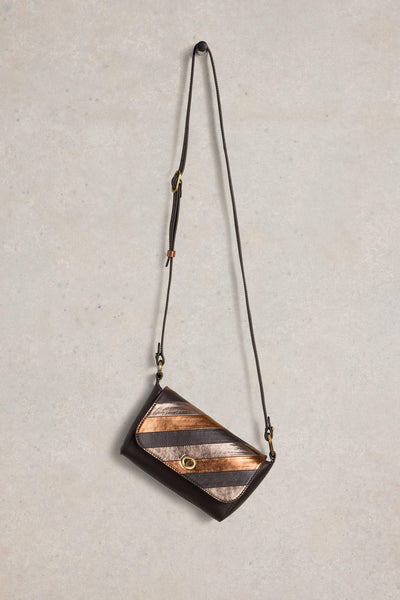 Crossbody bag with striped design on a textured beige background