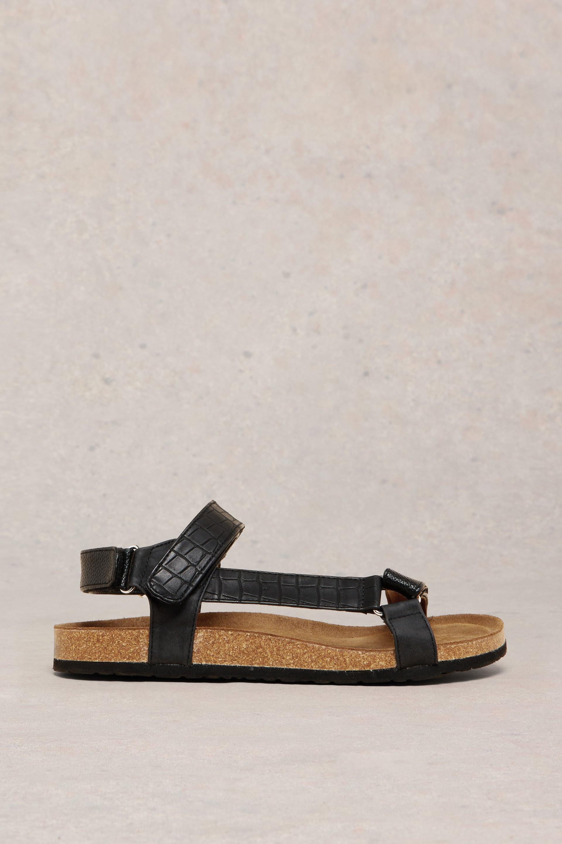 Side view of black strappy sandal.