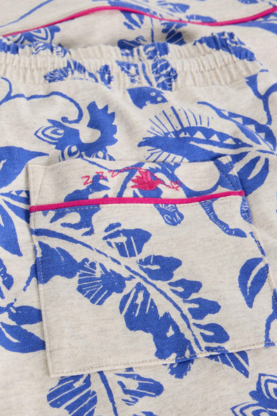 Close-up of a garment with blue floral pattern and pink stitching detail.