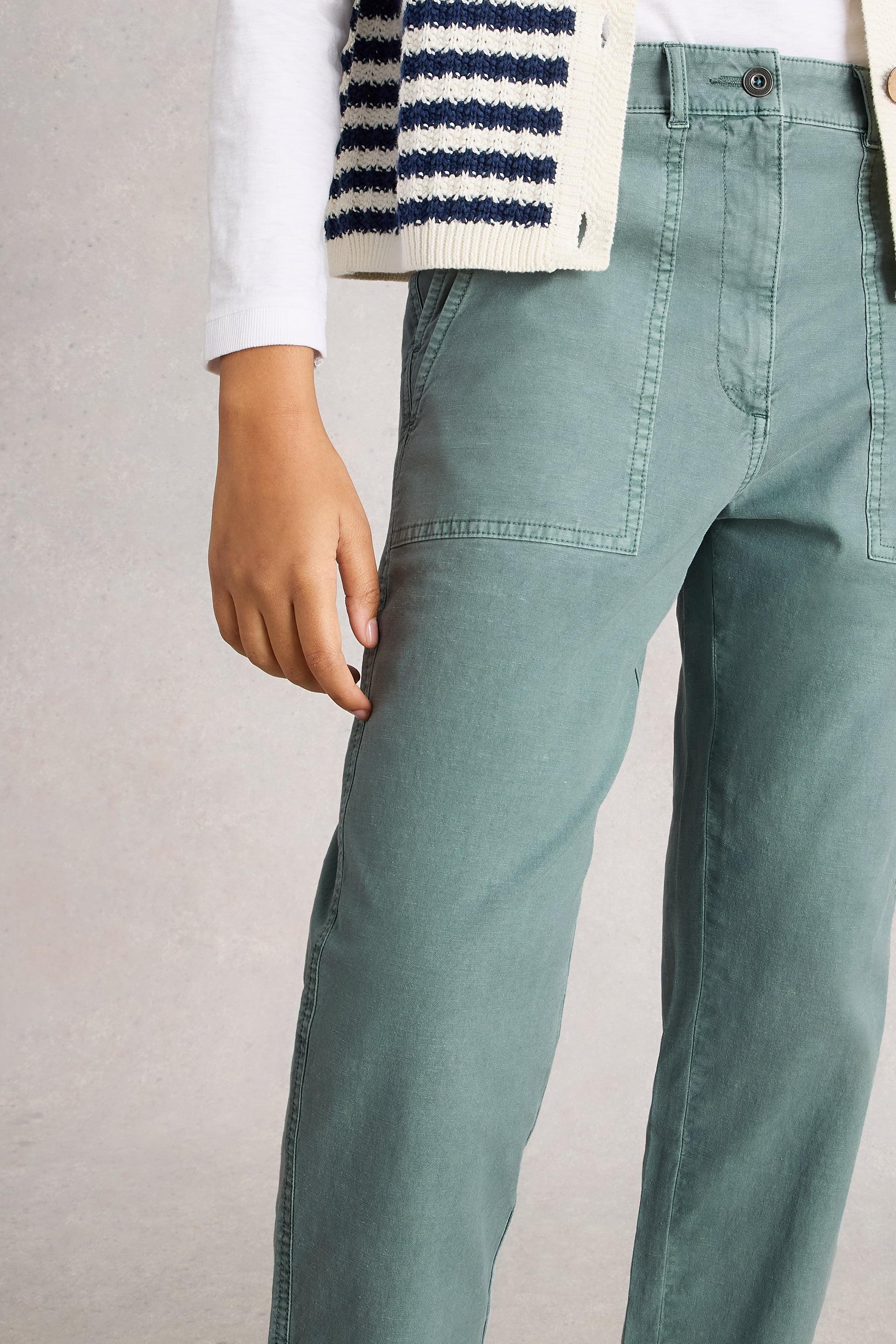 Person wearing blue pants with a neutral background