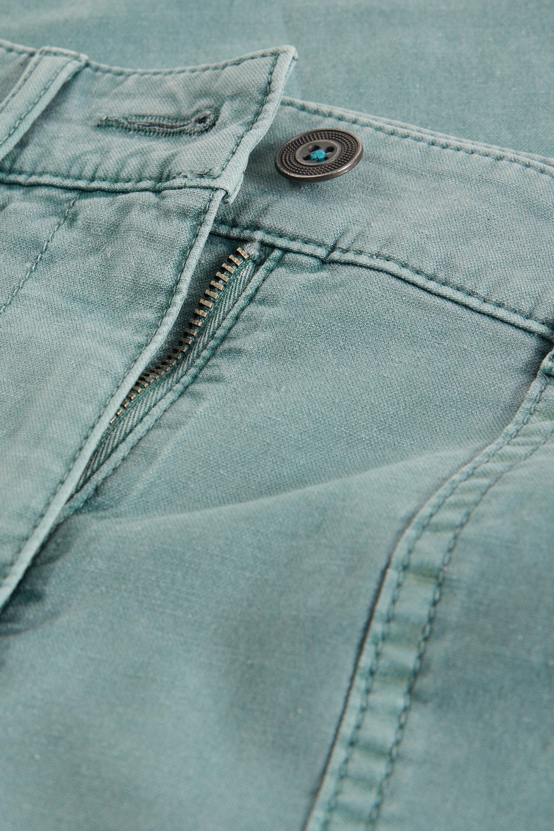 Close-up of a light blue fabric with a button and zipper.