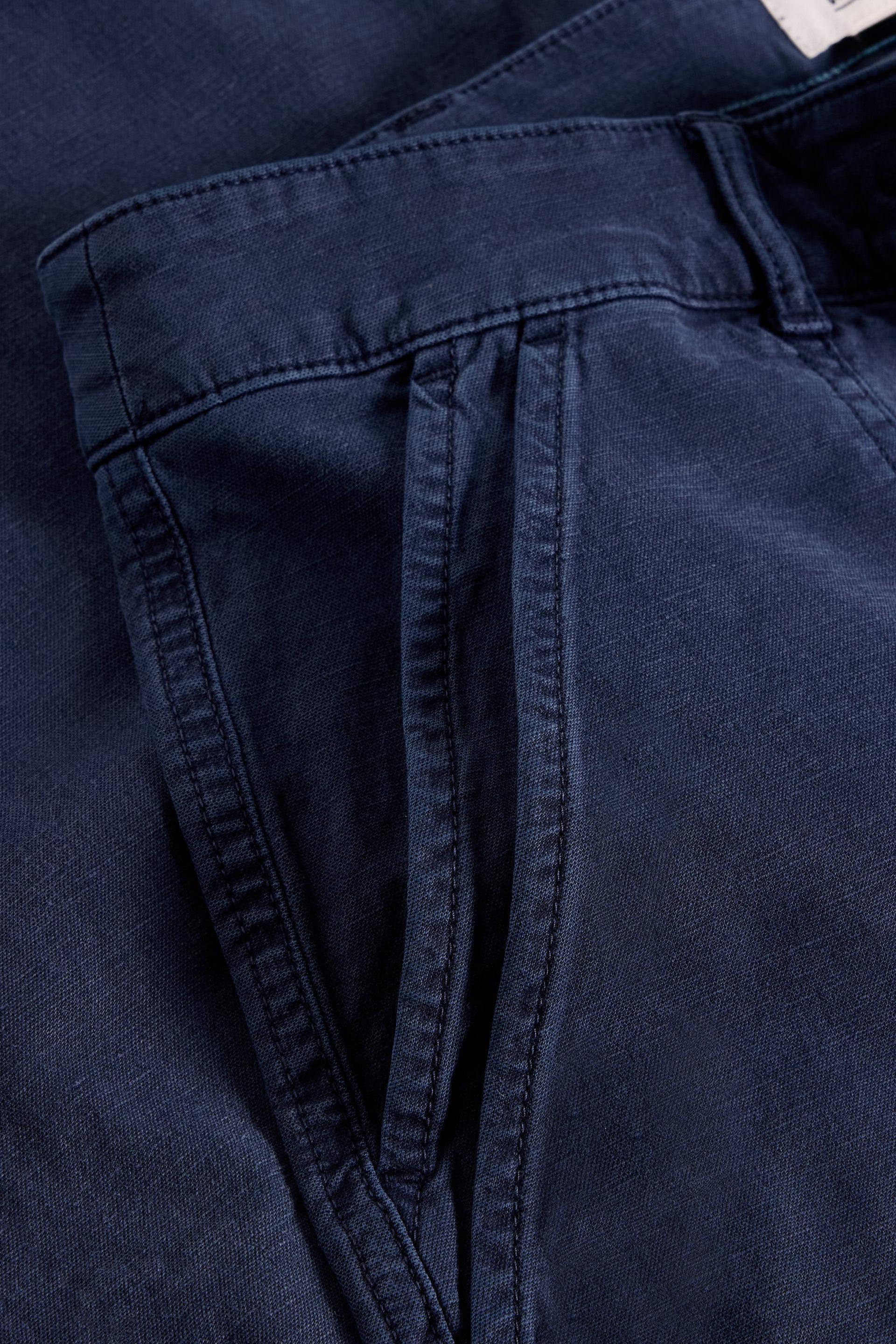 Close up of double pocket detail on navy wide leg chino trousers.