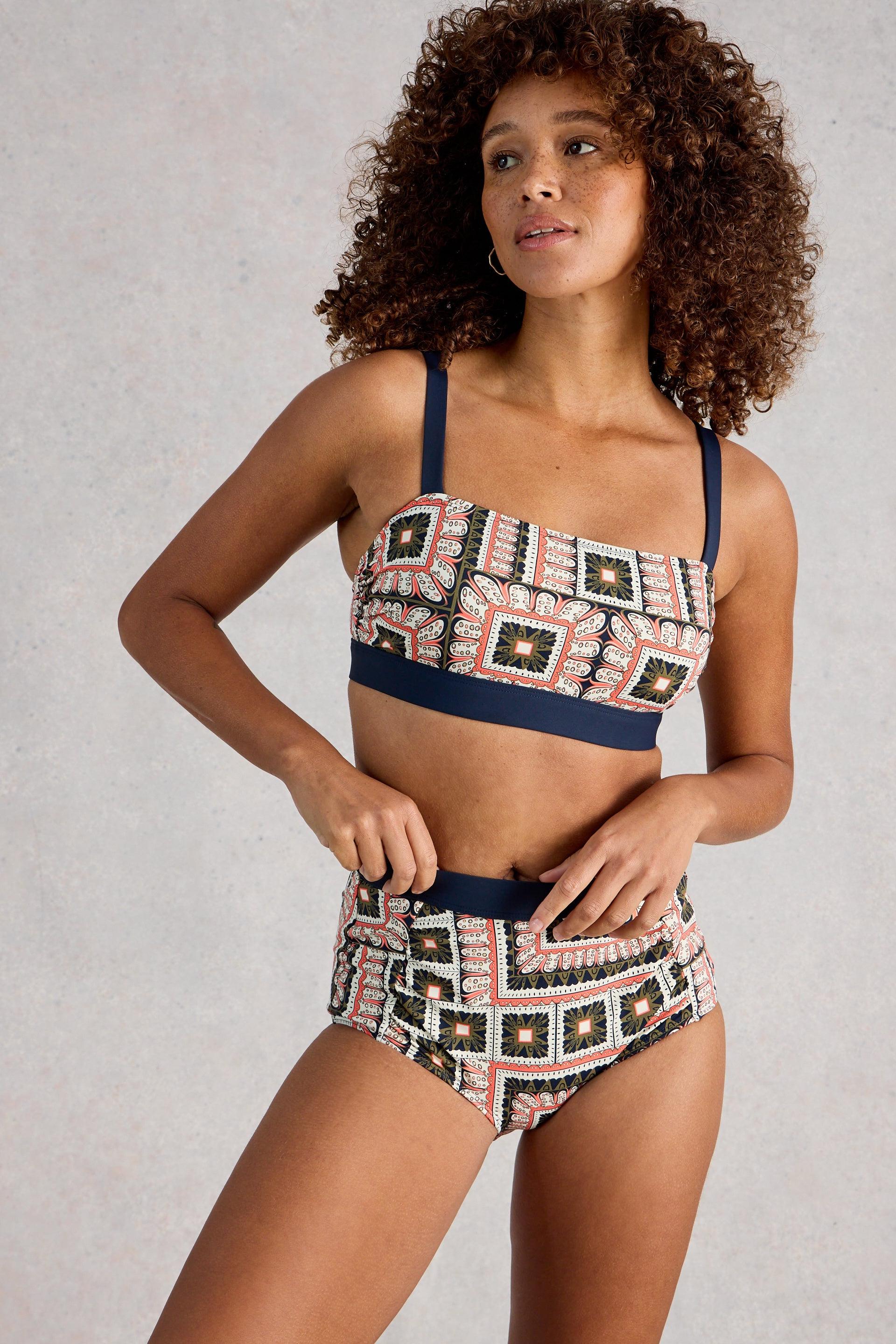 Woman wearing a patterned bikini set on a plain background