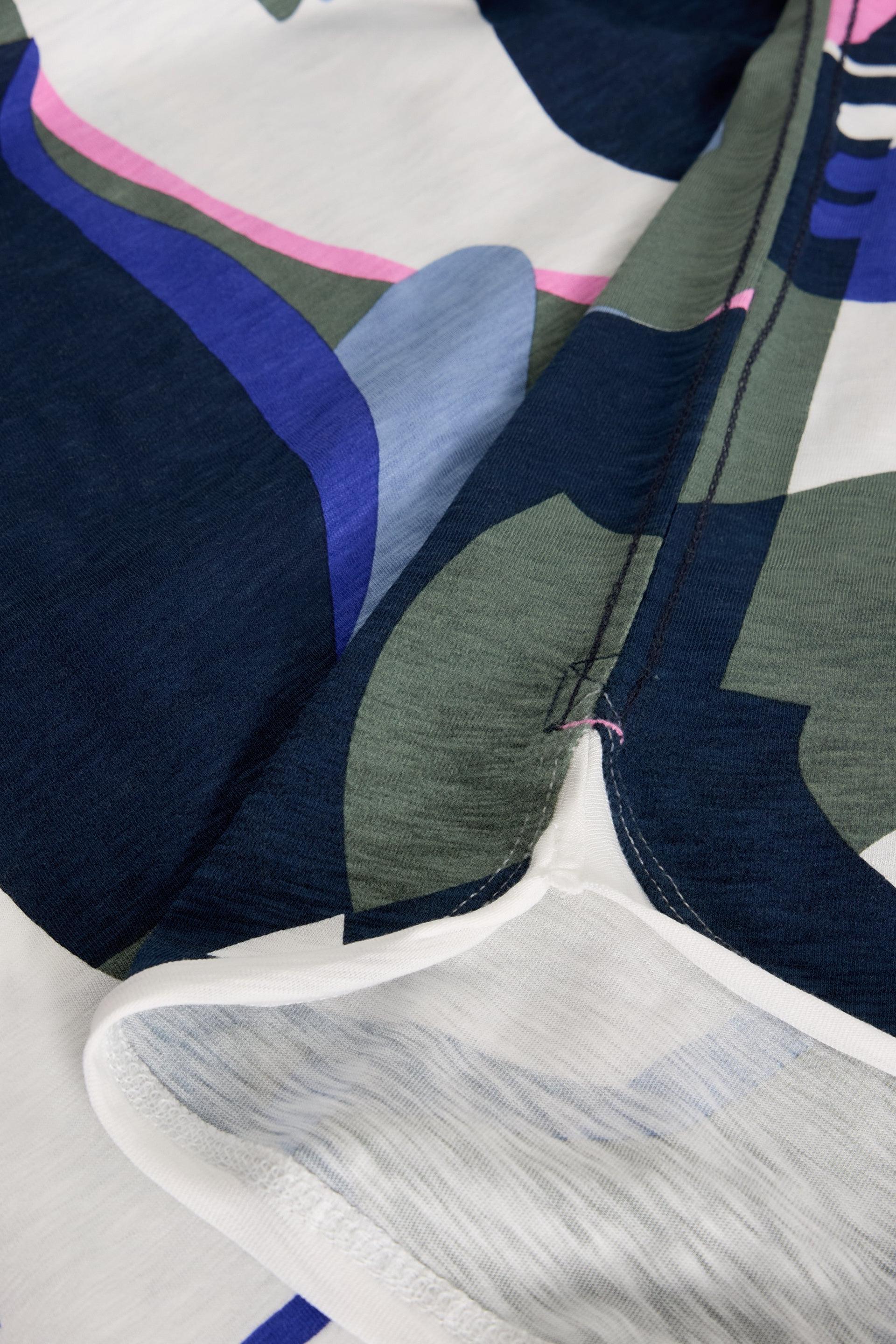 Close up of a White Stuff cotton garment featuring an abstract navy, green, and pink patterned fabric design.