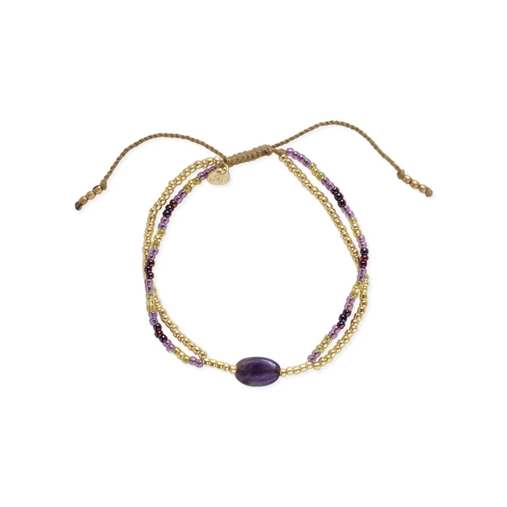 A delicate beaded bracelet featuring a central amethyst gemstone on a white background.