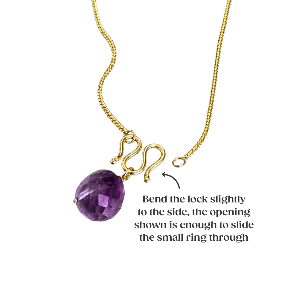 Gold necklace with an amethyst gemstone pendant featuring an instructional diagram on how to open the clasp.