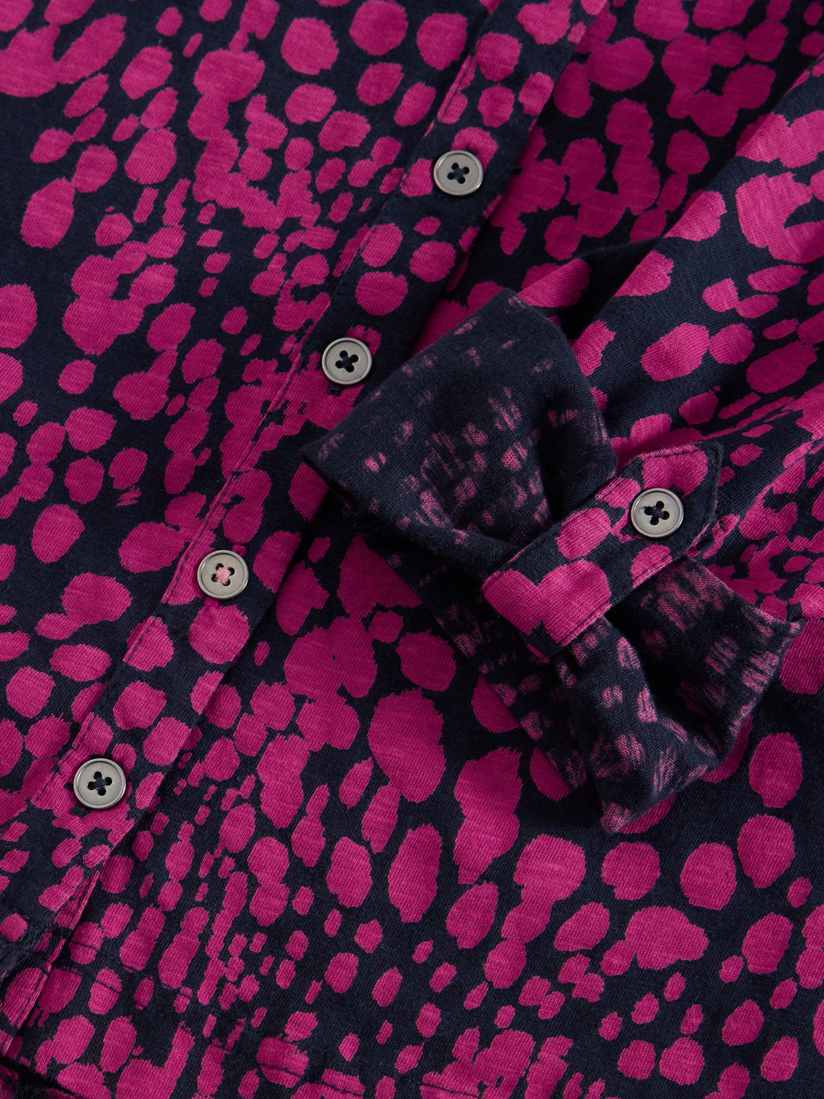 Close-up of a pink and navy printed cotton Annie jersey blouse with button-down detail.
