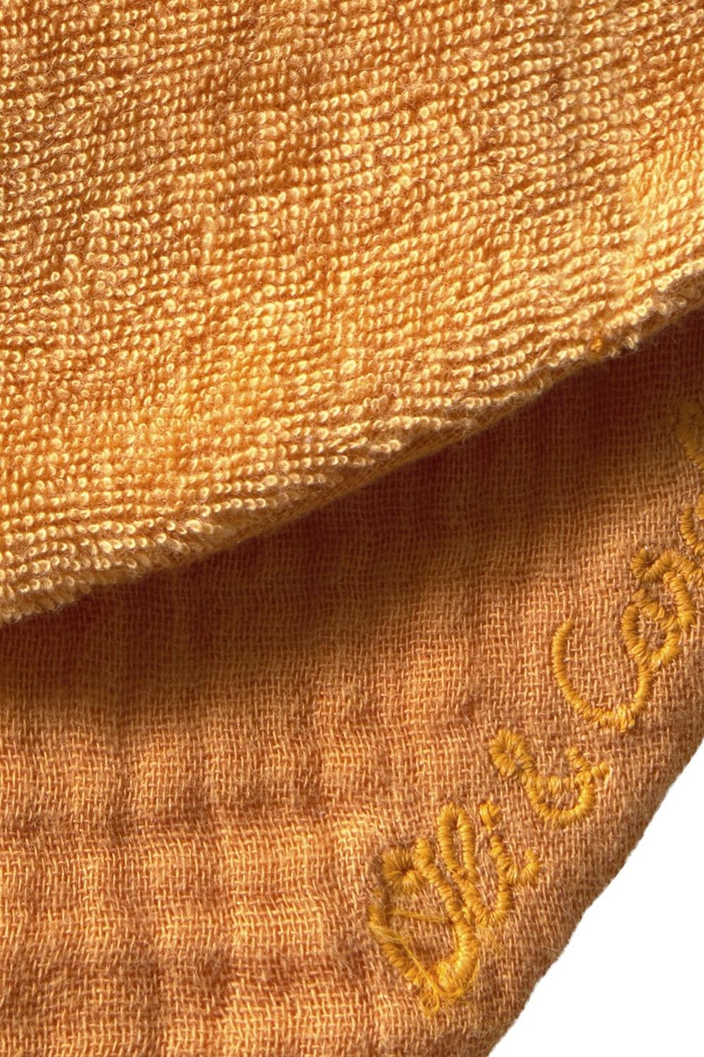 Close-up of textured organic cotton fabric with a logo on a white background