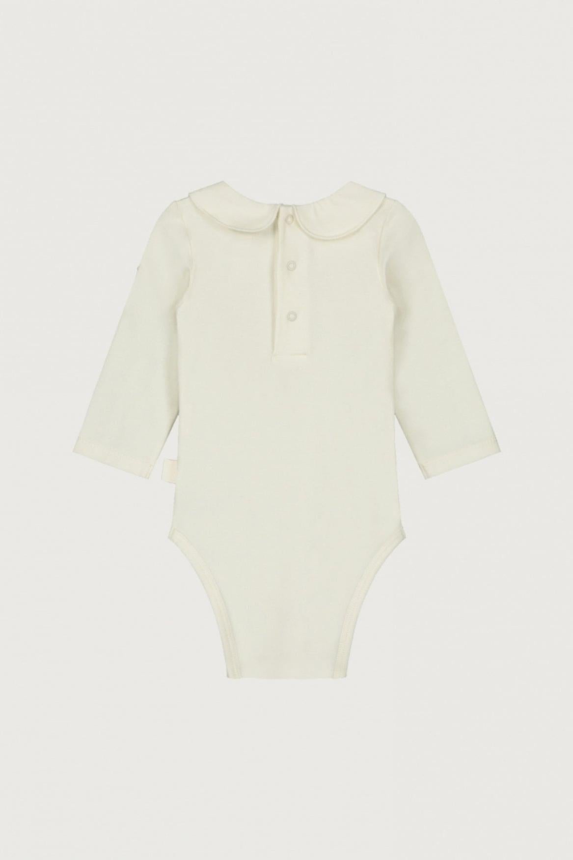 A long-sleeve baby bodysuit in a soft cream or off-white color, featuring a Peter Pan collar and a three-button henley neckline, shown flat against a light off-white background.