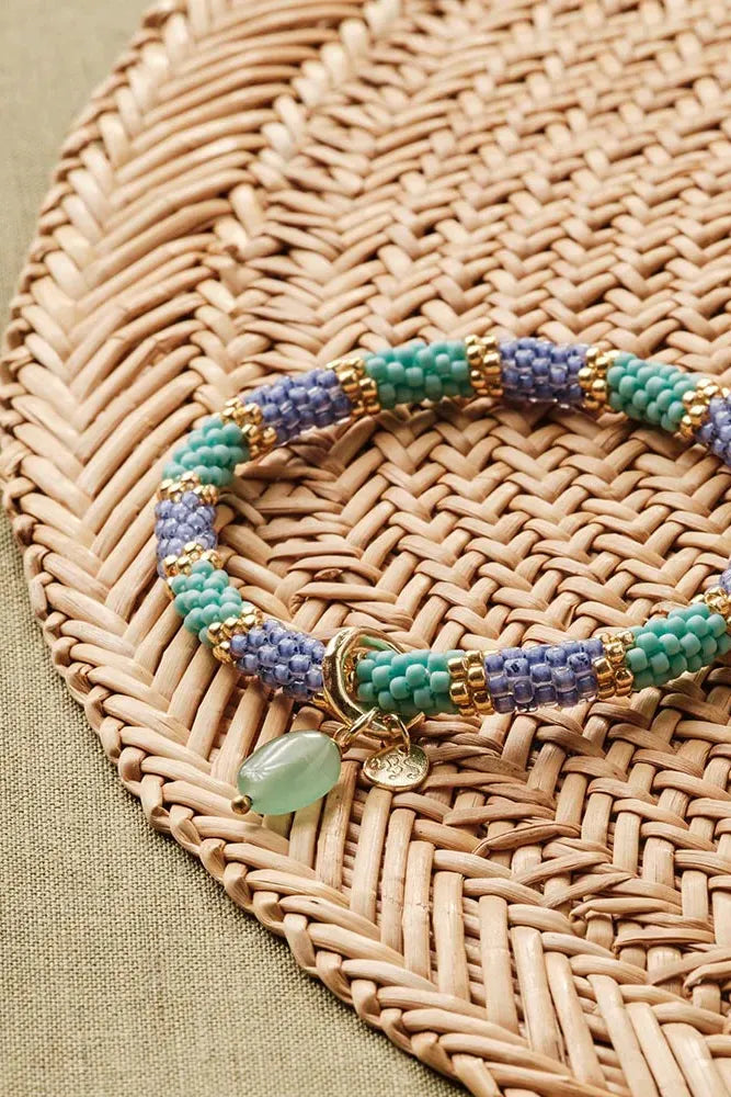 Multicolored beaded bracelet on a woven mat