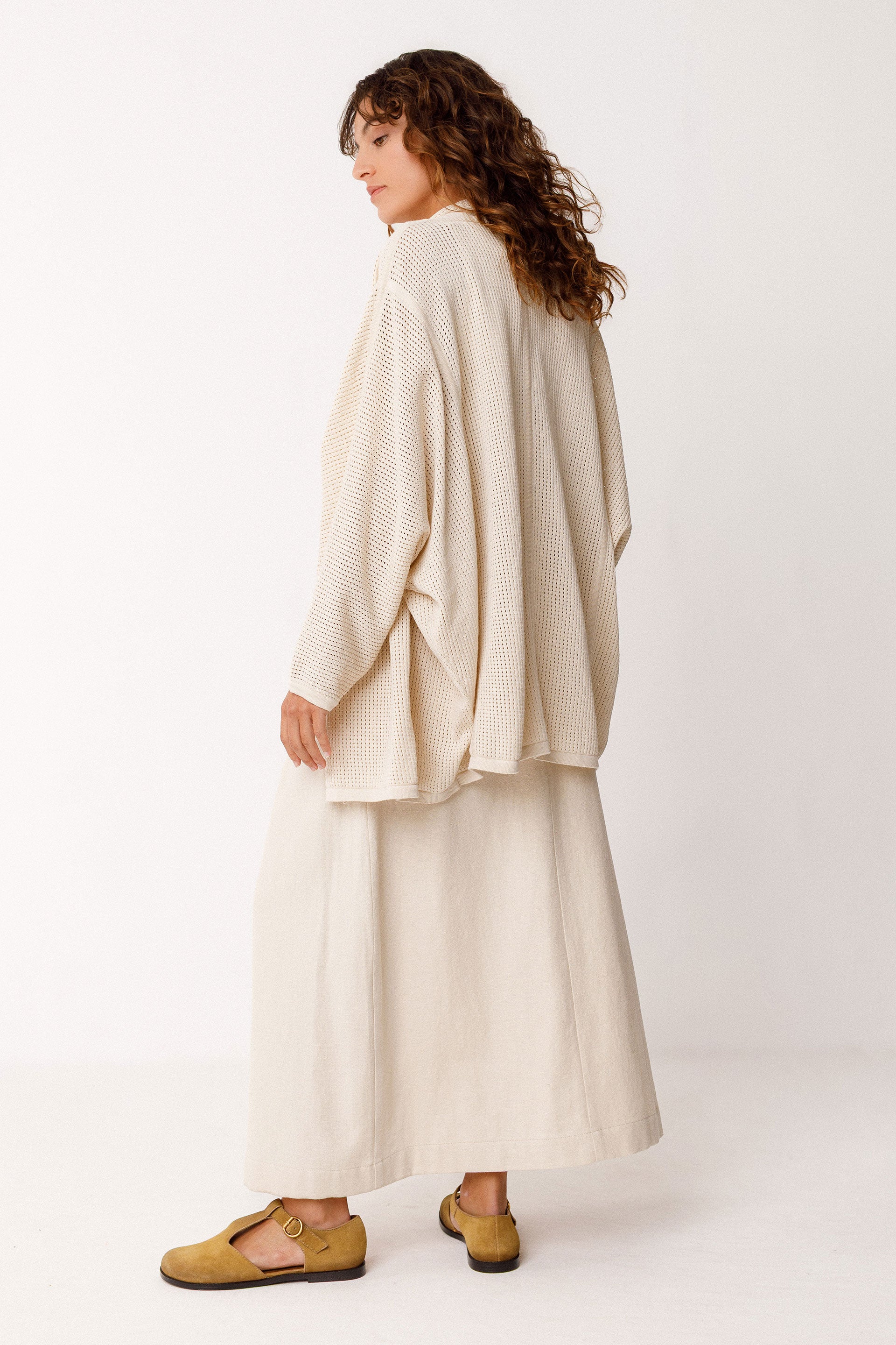 Woman wearing a cream-colored outfit with a white background