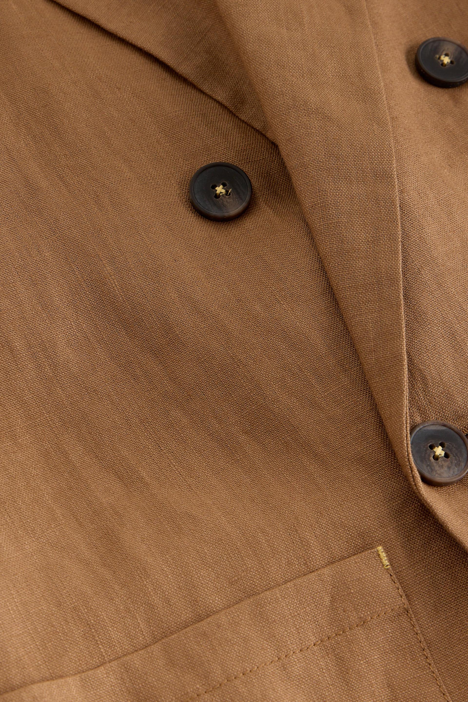 Close-up of a brown blazer with dark buttons
