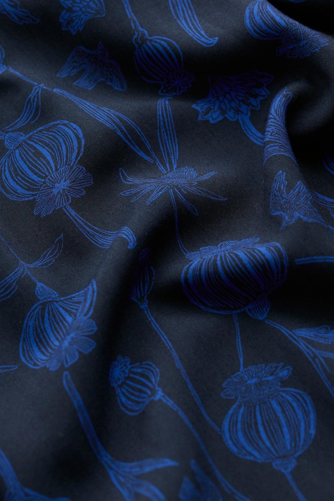 Close-up of black fabric with a vibrant blue floral print pattern