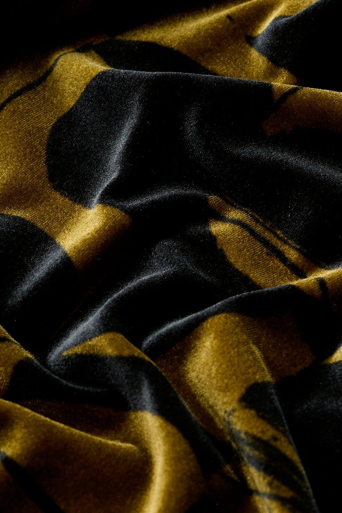 Close-up of luxurious black and gold patterned velvet fabric from a Seasalt winter party dress.
