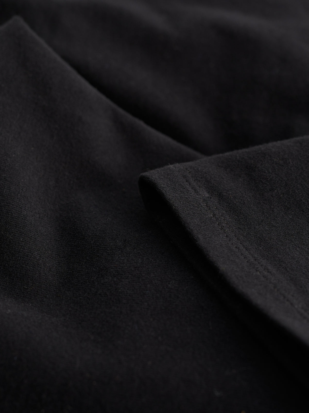 Close-up of black organic cotton fabric showing the smooth texture and stitching of Seasalt Cornwall women's leggings.