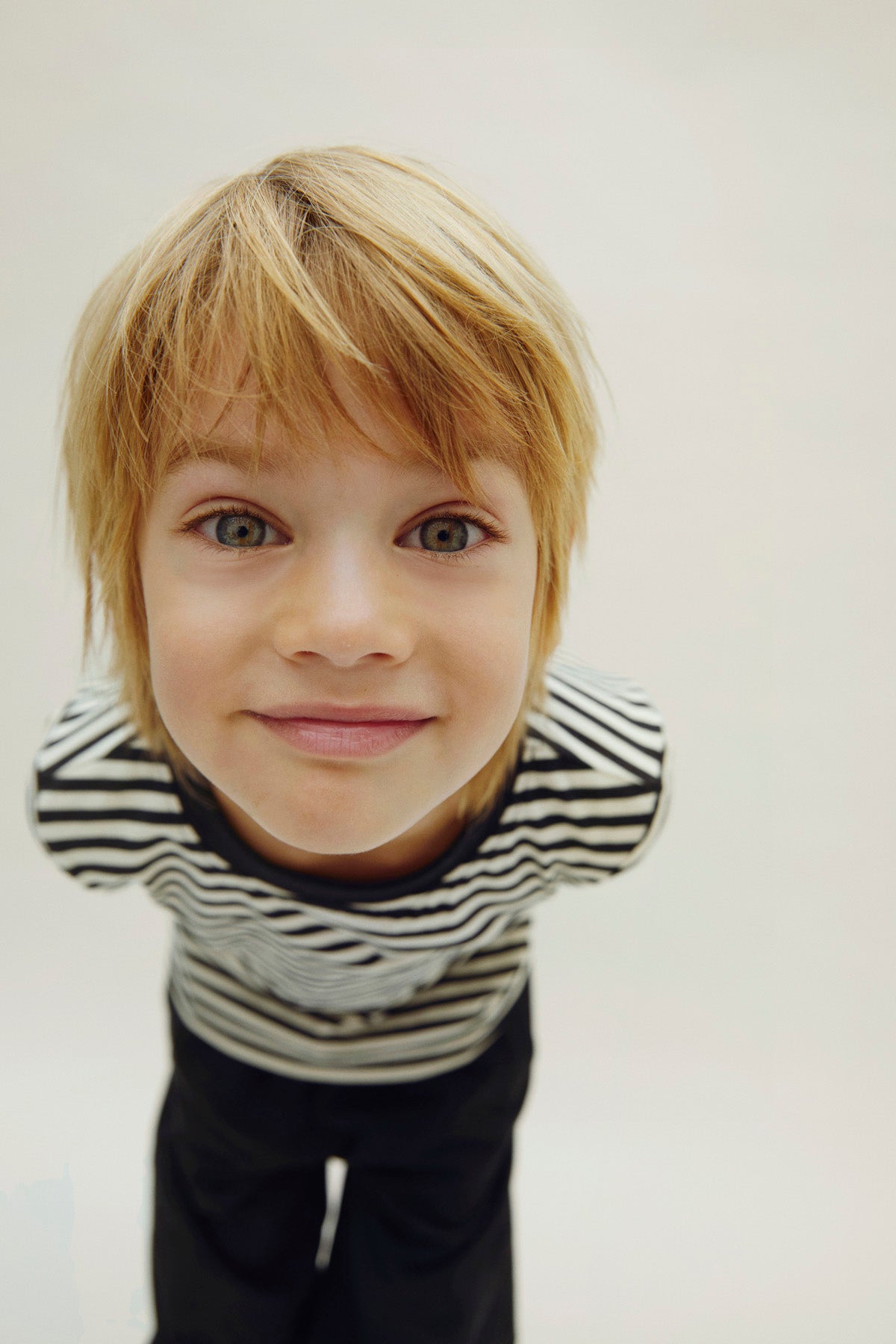 Child wearing a striped shirt with a plain background