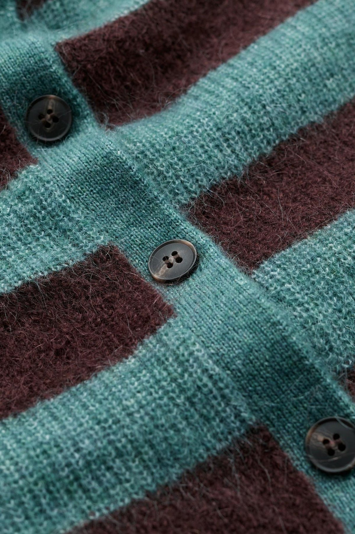 Close-up of a blue and brown striped mohair wool knit cardigan with buttons.