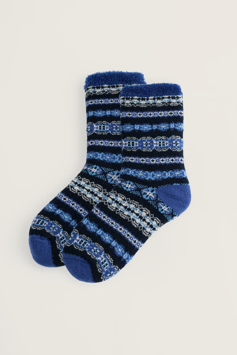 A pair of navy and light blue patterned fluffy cabin socks against a neutral background.