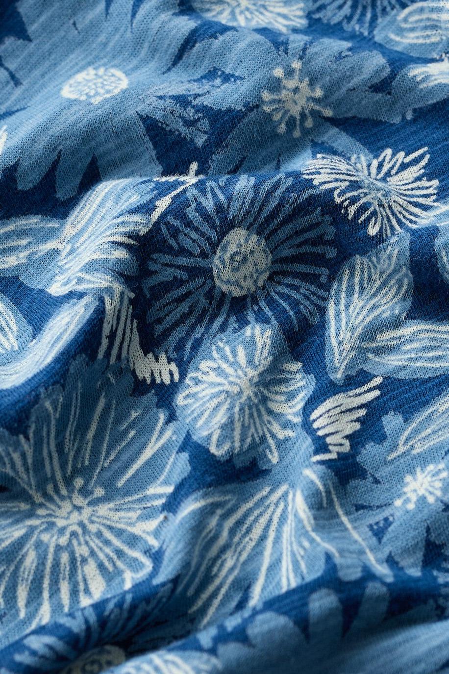 A close-up of a blue and white floral patterned fabric, showing the texture and detailed print.