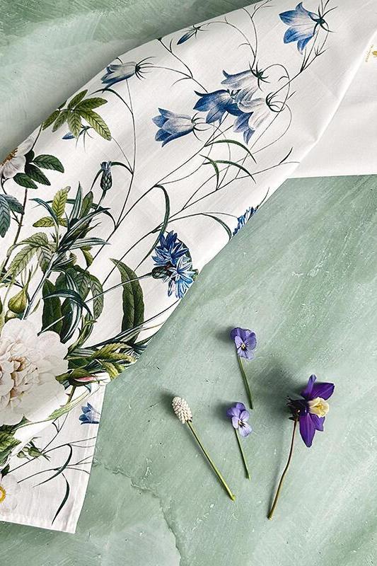 Floral-patterned dish cloth with real flowers on a textured green background