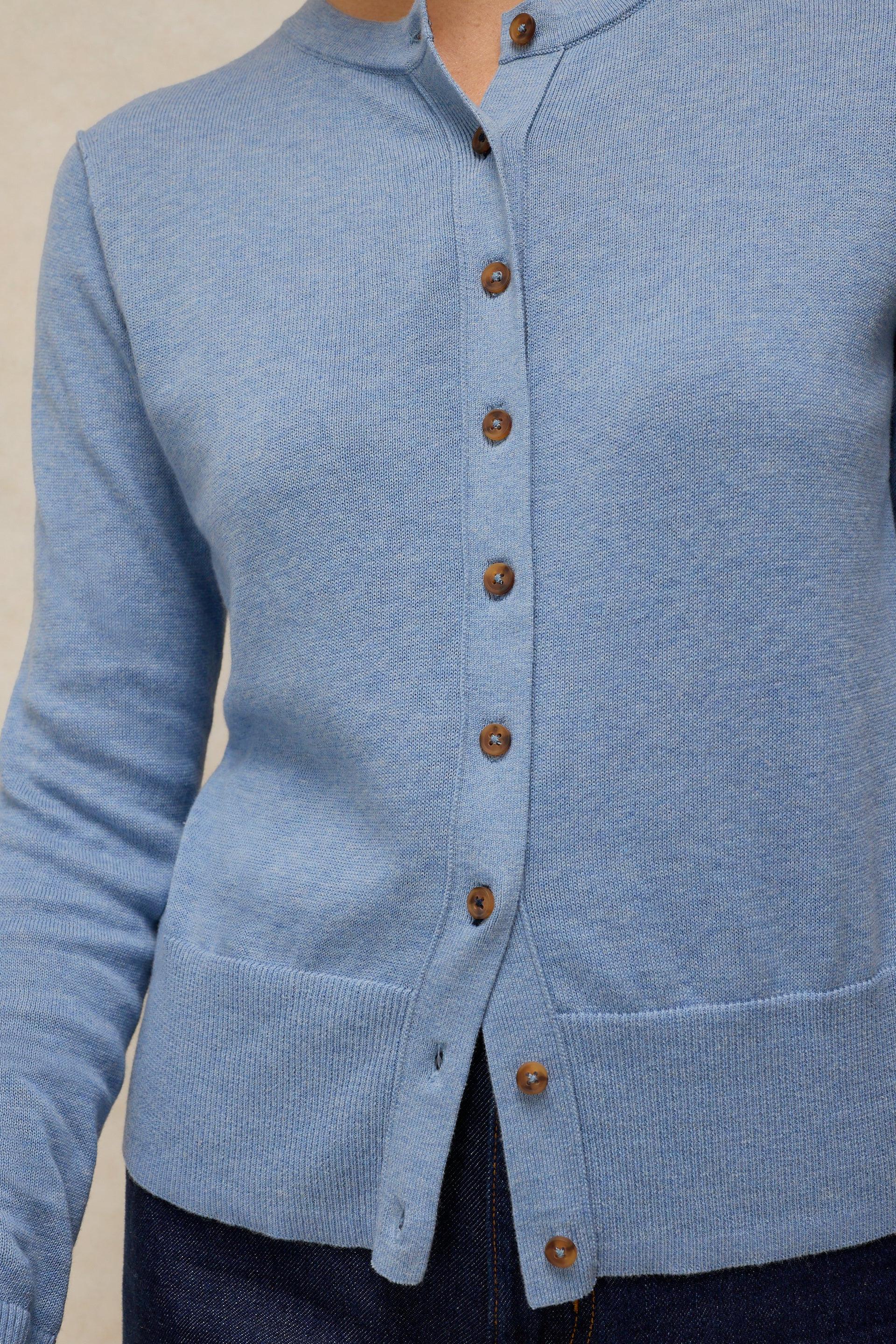 Close up of a blue knitted button-down cardigan made from organic cotton by White Stuff