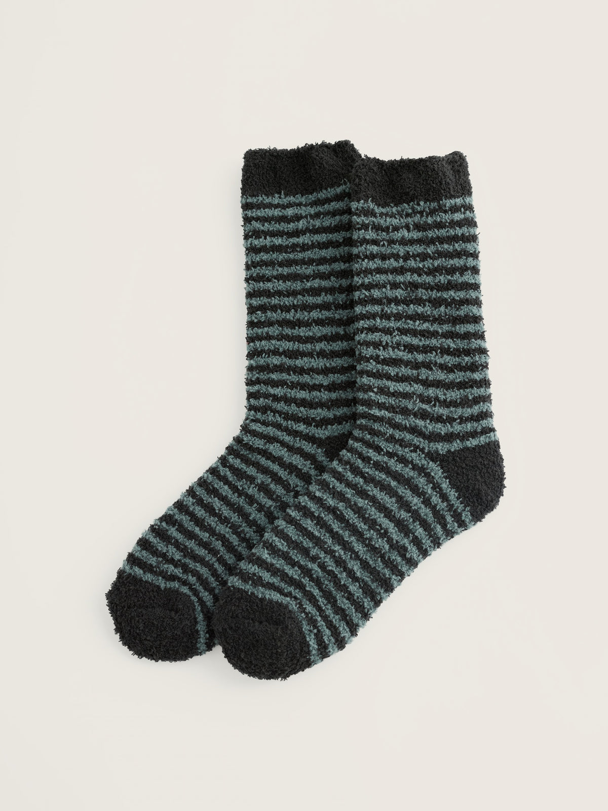 A pair of fluffy blue and black striped cosy socks on a neutral background.