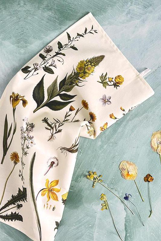 Floral-patterned tea towel on a textured teal background