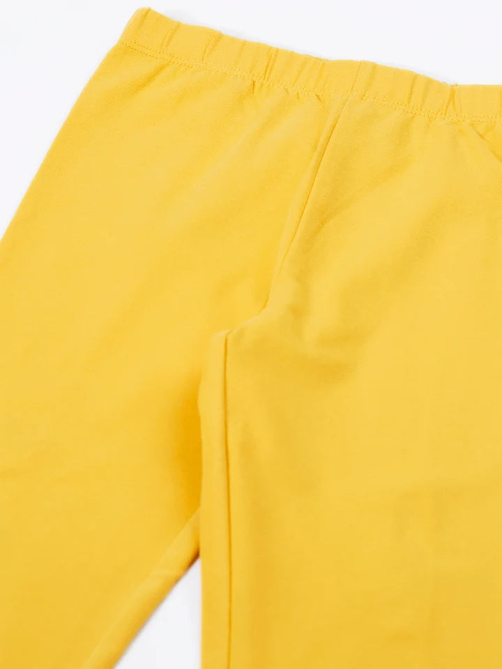 A close-up view of bright yellow organic cotton kids leggings against a plain white background.