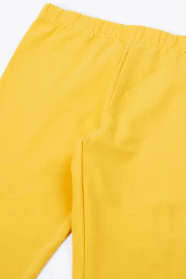 A close-up view of bright yellow organic cotton kids leggings against a plain white background.