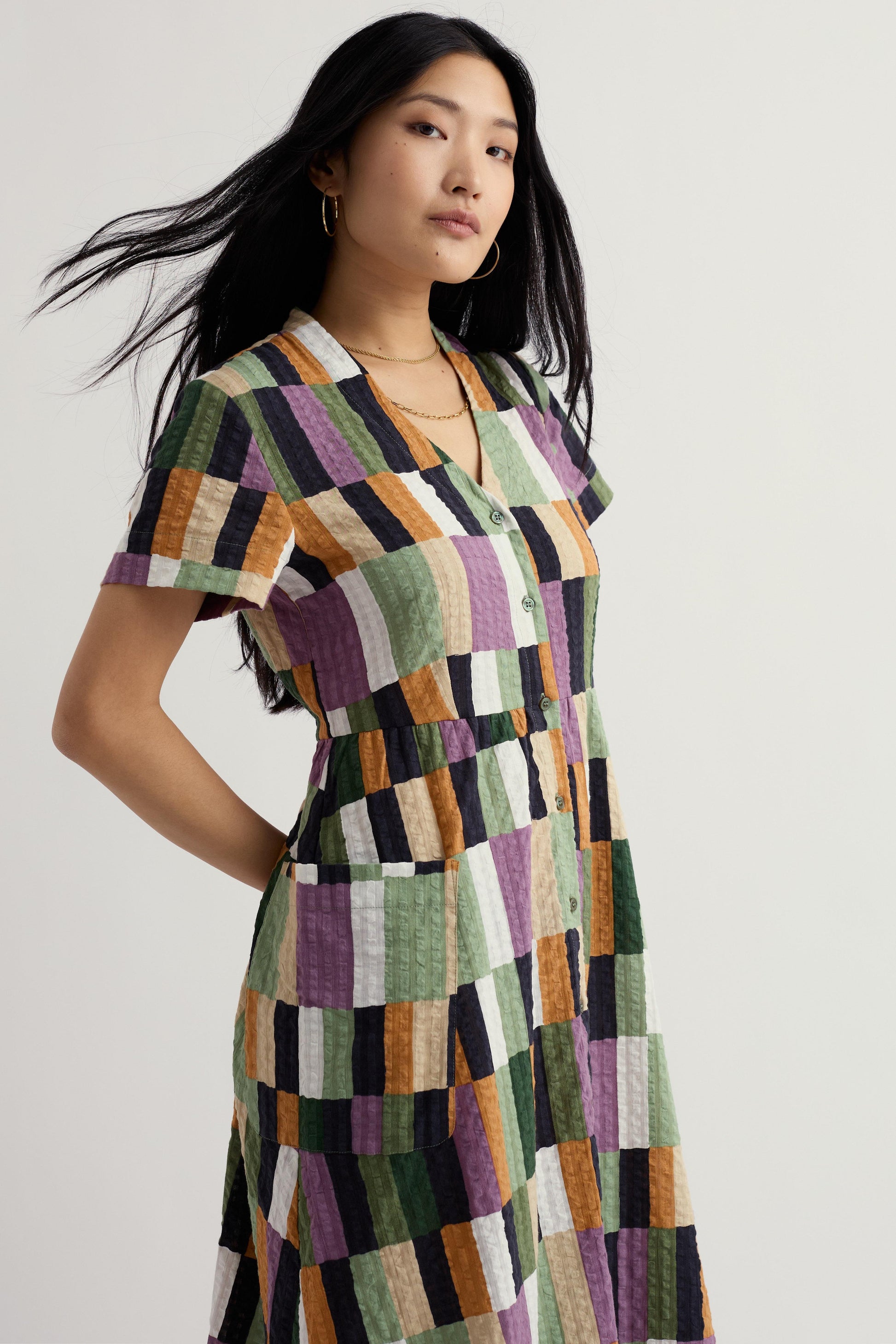 Woman wearing a patchwork organic cotton dress with a neutral background