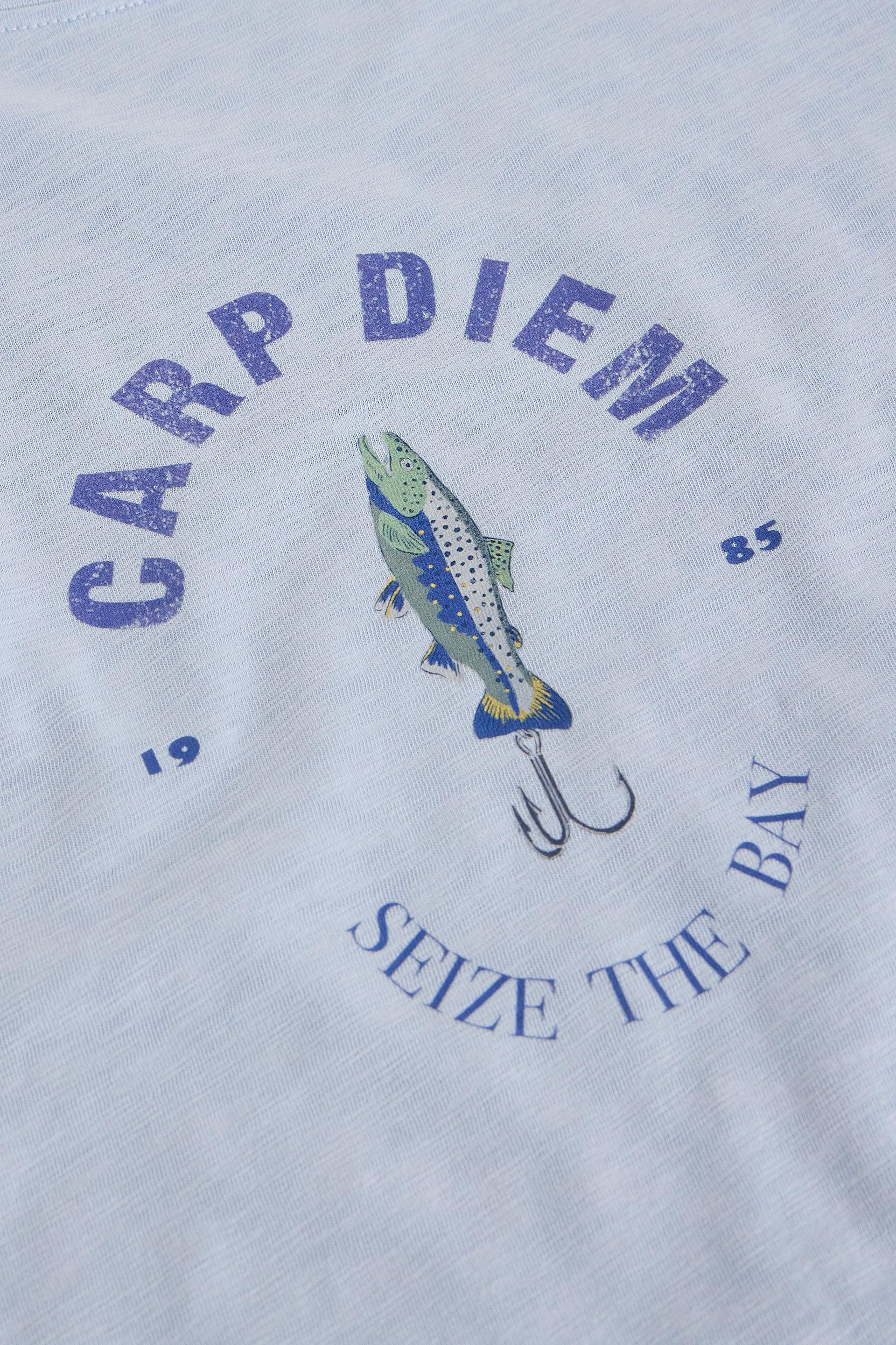 Close-up of a blue heathered t-shirt featuring a blue graphic print with a fishing lure, a fish, and the text 'CARP DIEM' and 'SEIZE THE BAY'.