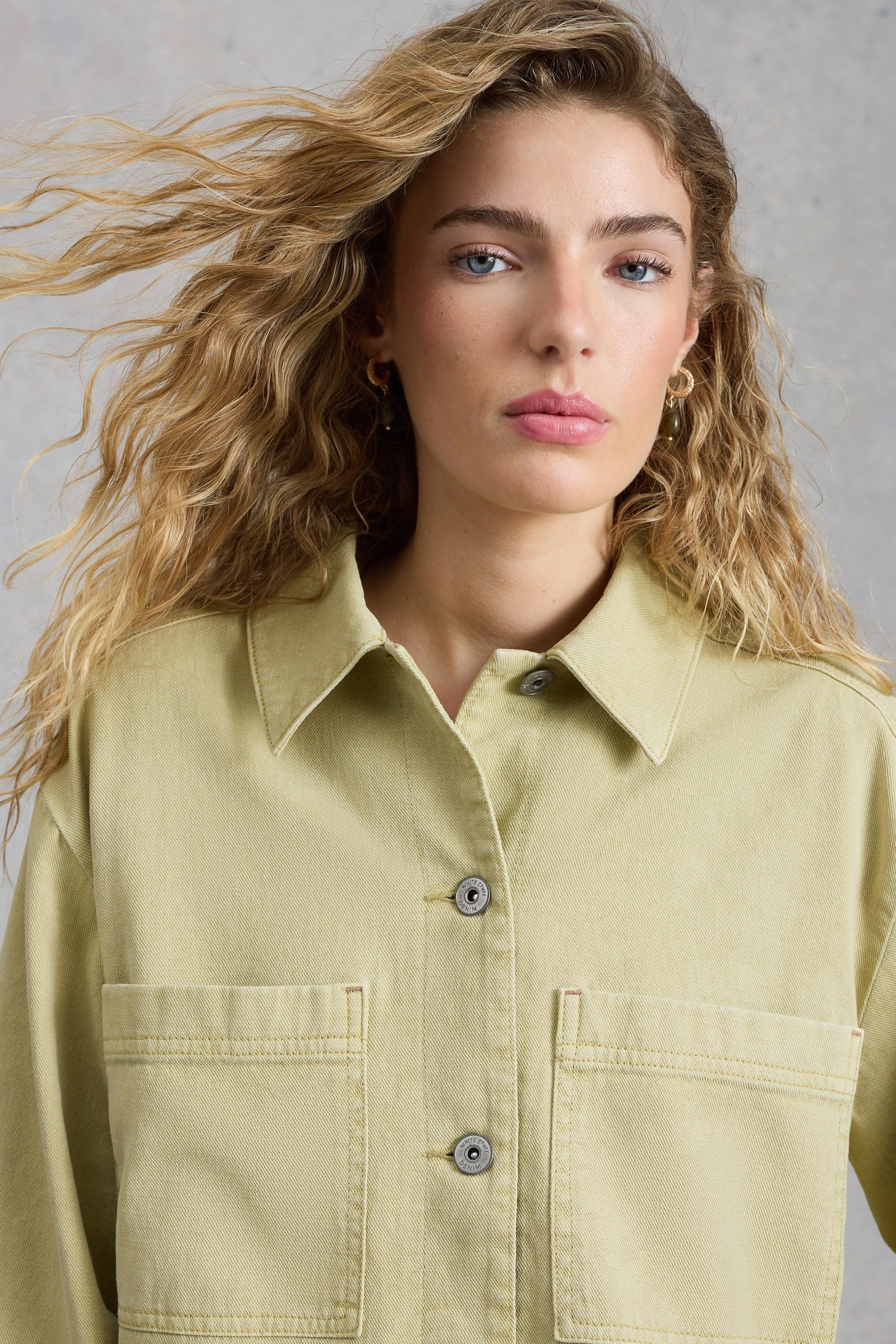 Woman wearing a light green shirt against a neutral background