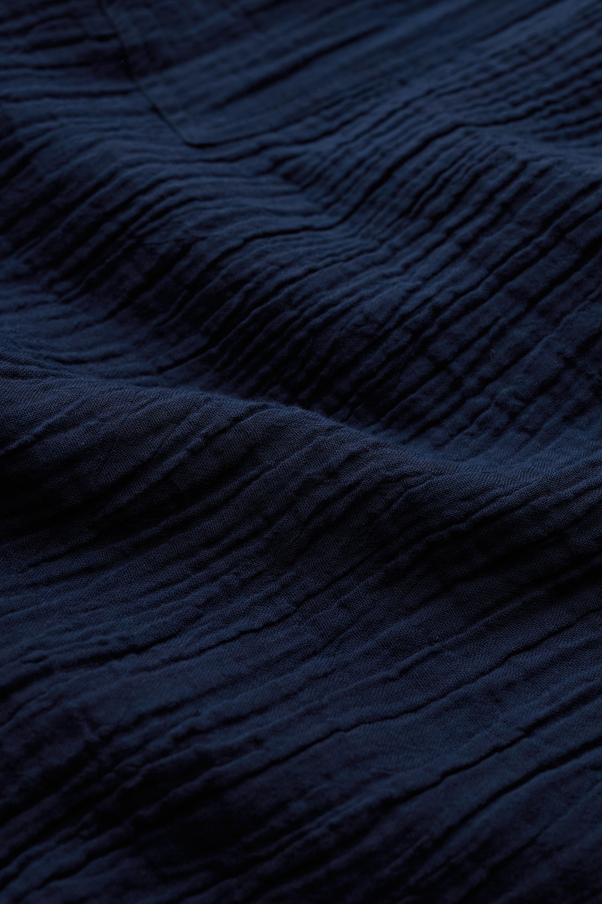 Close-up of dark blue organic cotton fabric with visible texture