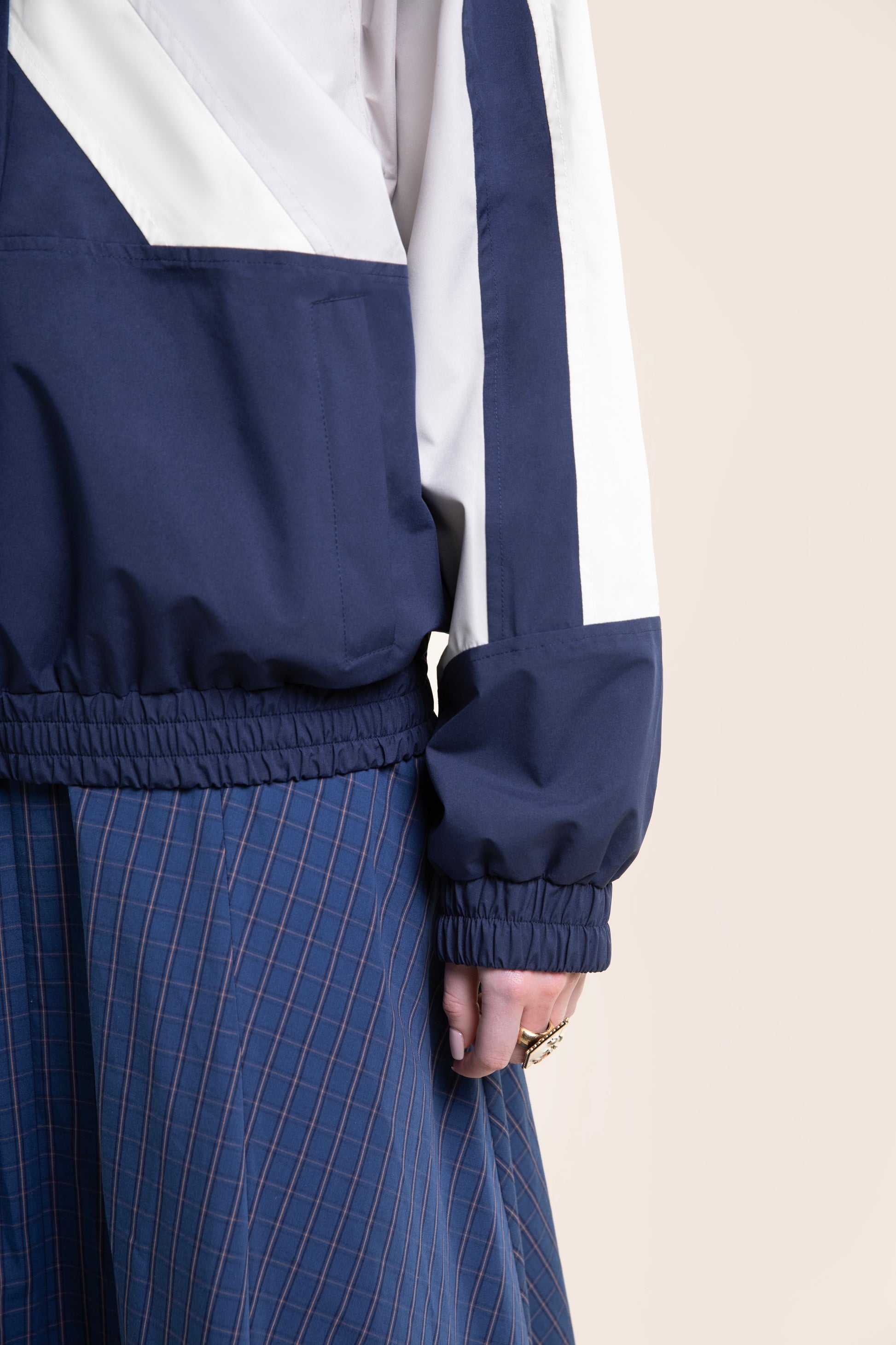Close up of a navy and white waterproof unisex jacket with a plaid skirt