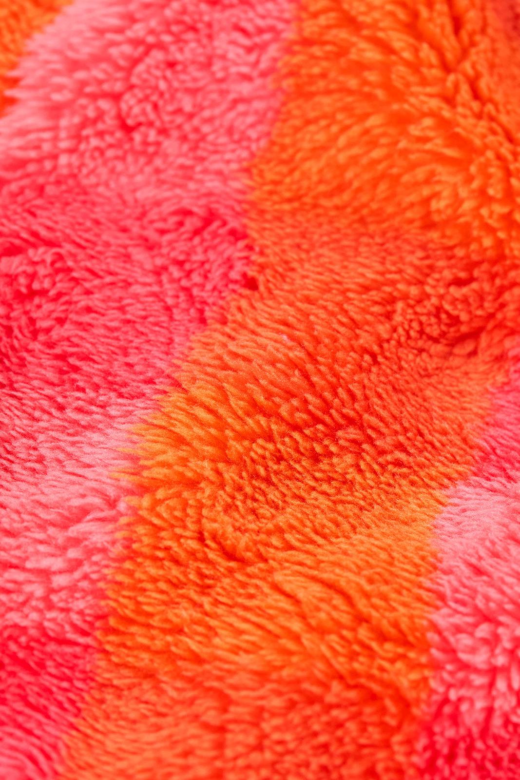 Close-up of a colourful Frugi girls fleece made from soft, recycled polyester with orange and pink stripes.