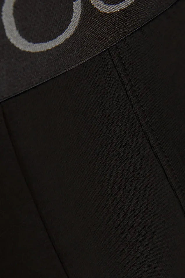 Close-up detail of a black Comazo organic cotton boxer brief waistband with logo branding.