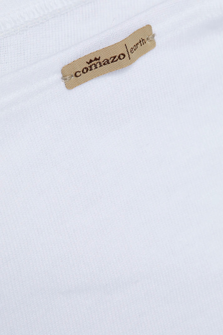 Close-up of a Comazo earth clothing label stitched onto white organic cotton fabric.