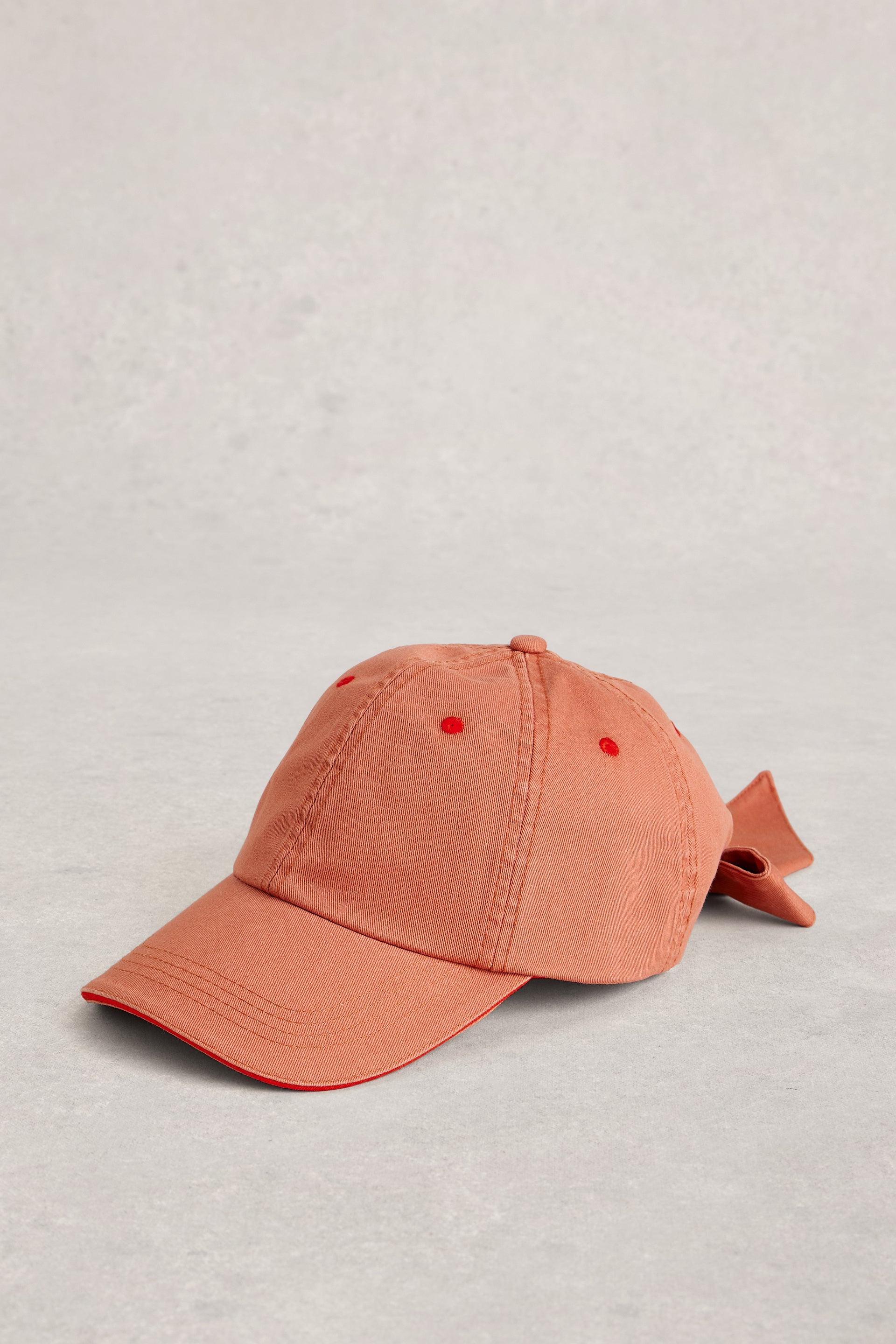 Orange baseball cap on a grey background