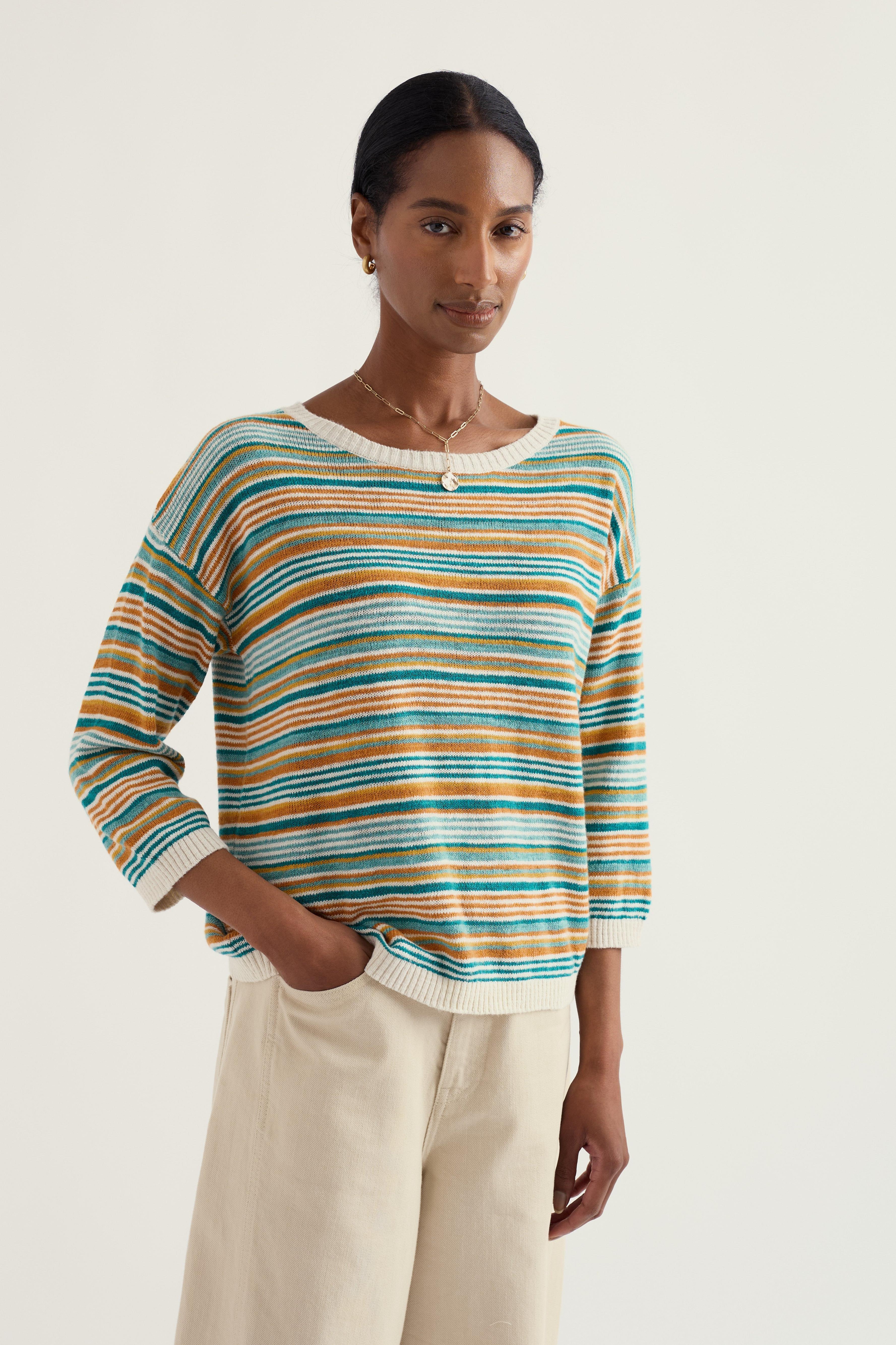 Woman wearing a striped linen sweater with a plain background