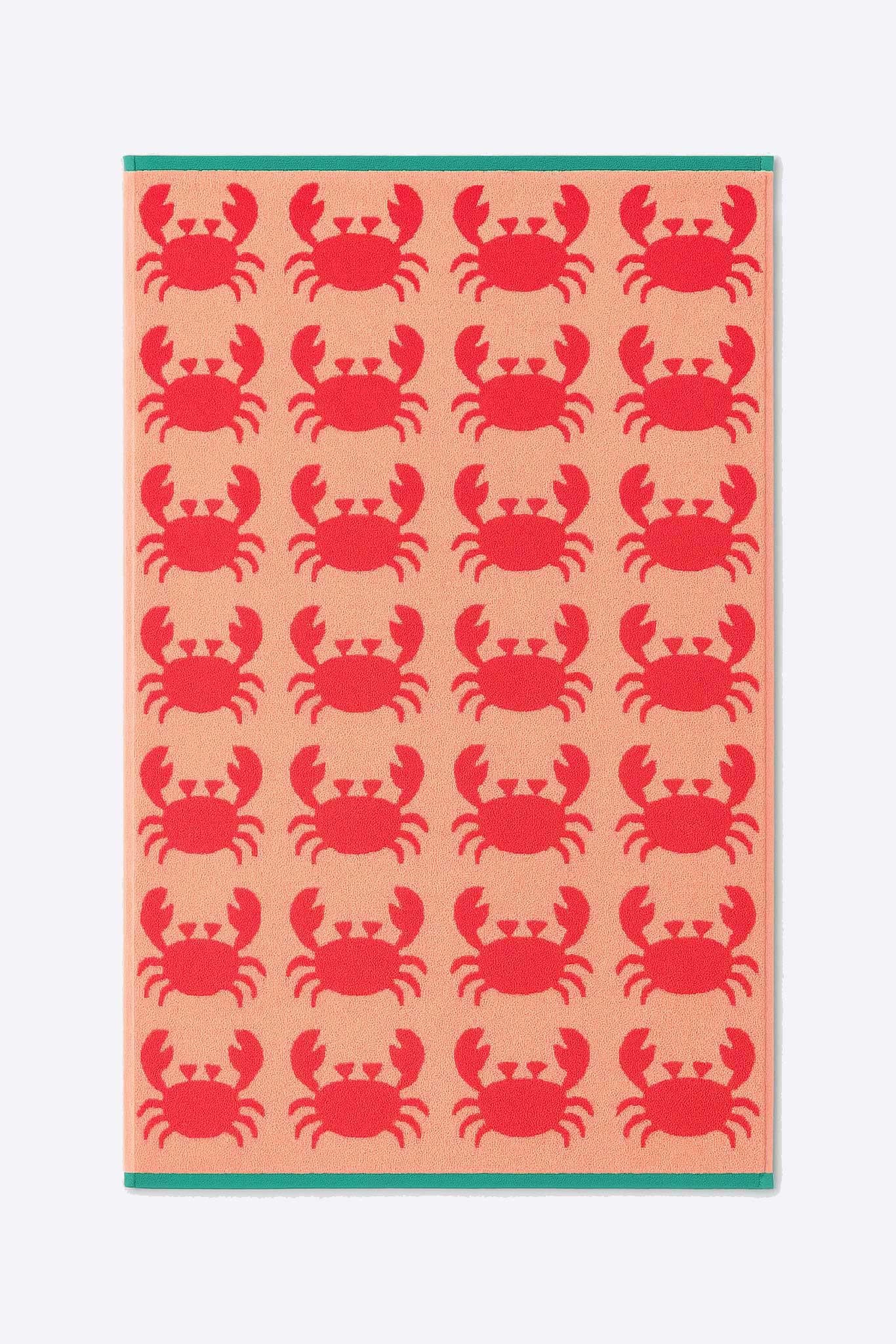 Towel with red crab pattern on a pink background